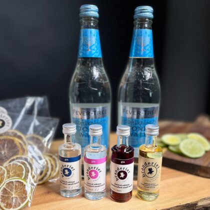 En elegant gavepakke med fire forskellige gin-varianter, to flasker Fever Tree Mediterranean Tonic og en pose lime garnish – perfekt til at skabe en udsøgt gin & tonic-oplevelse.